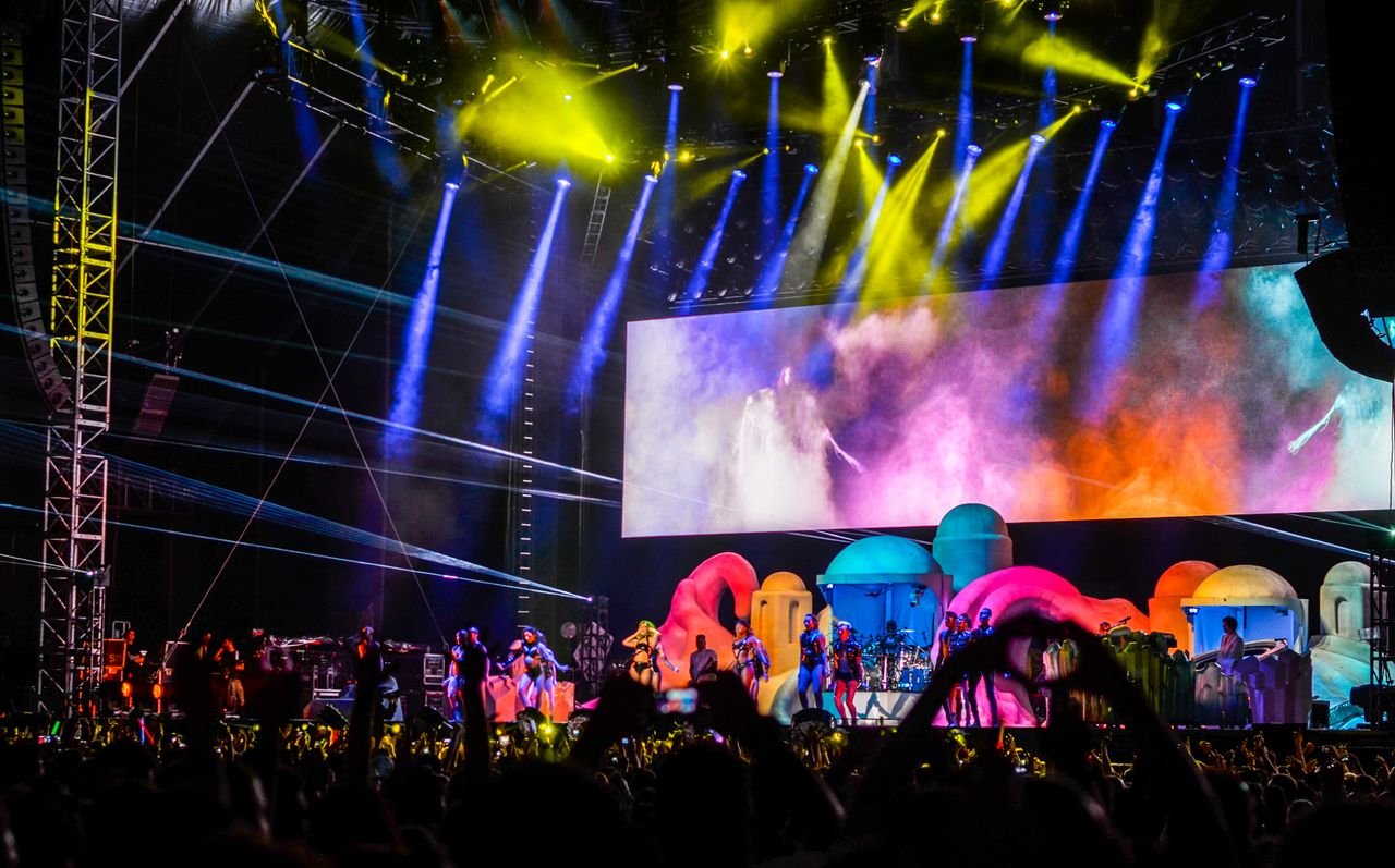about-us Energetic concert scene with colorful lights and performers on stage