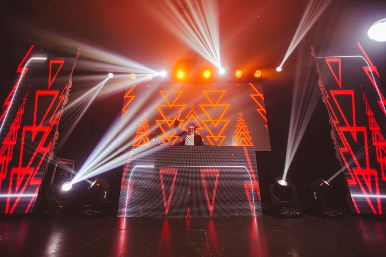 Energetic DJ performance with colorful lights and visual effects, creating a dynamic nightlife atmosphere.