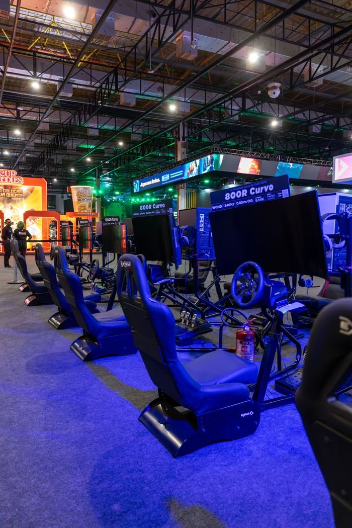 Virtual racing arcade setup with gaming simulators in a vibrant evening ambiance.