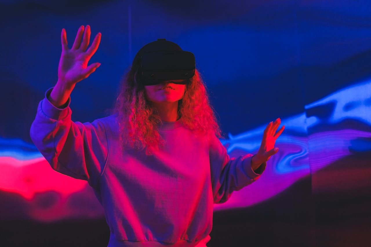 The Art of Drawing Readers In: Your attractive post title goes here A woman immersed in a vivid virtual reality experience with colorful LED lighting.
